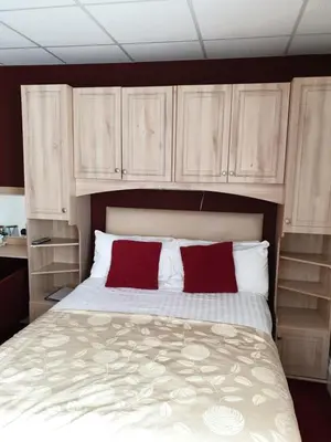 a bedroom with a bed with two red pillows at The Montclair in Blackpool