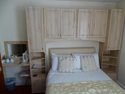 a bedroom with a bed with wooden cabinets at The Montclair in Blackpool