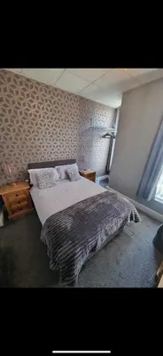 a bedroom with a large bed and a window at The Montclair in Blackpool