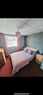 a bedroom with a large bed with pink sheets at The Montclair in Blackpool