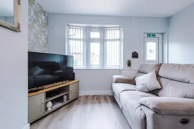 a living room with a couch and a flat screen tv at Charming & Modern 4 bed, ideal for contractors and leisure in Egerton