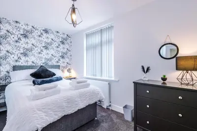 a bedroom with a bed and a dresser at Charming & Modern 4 bed, ideal for contractors and leisure in Egerton