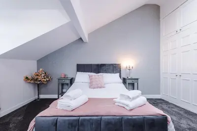 a bedroom with a large bed with two night stands at Charming & Modern 4 bed, ideal for contractors and leisure in Egerton