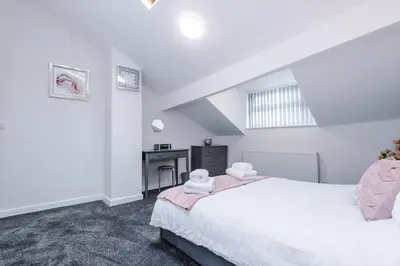 a white bedroom with a bed and a desk at Charming & Modern 4 bed, ideal for contractors and leisure in Egerton