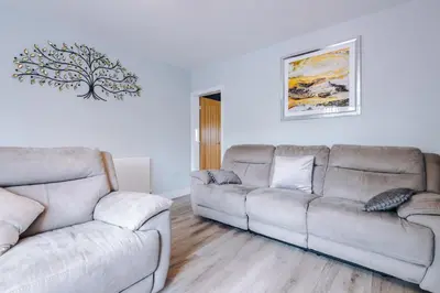 a living room with two couches and a table at Charming & Modern 4 bed, ideal for contractors and leisure in Egerton