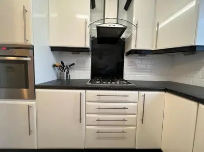 a kitchen with white cabinets and a stove top oven at Cheerful 2 Bedroom Home with Off-road parking in Deysbrook