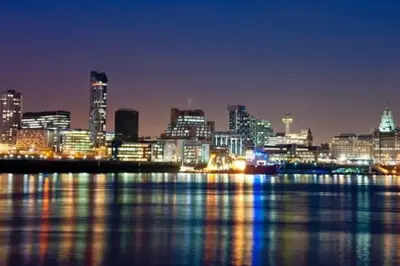 a city skyline at night with the water and buildings at Cheerful 2 Bedroom Home with Off-road parking in Deysbrook
