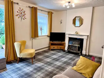 a living room with a couch and a fireplace at Cheerful 2 Bedroom Home with Off-road parking in Deysbrook