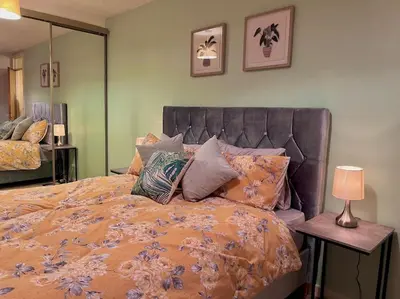 a bedroom with a large bed with pillows and a lamp at Cheerful 2 Bedroom Home with Off-road parking in Deysbrook