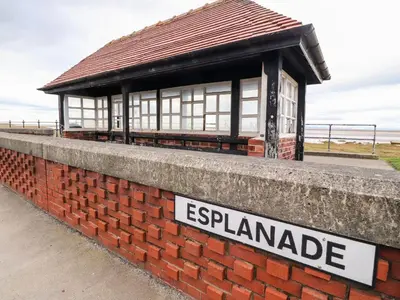 a brick wall with a sign in front of a building at Flat 3, Sandridge Court in Fleetwood