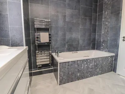 a bathroom with a tub and a sink at Flat 3, Sandridge Court in Fleetwood