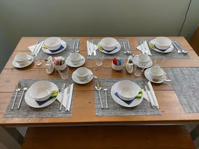 a wooden table with white plates and silverware on it at Lee & Chris's Belvedere - Adults Only in Blackpool