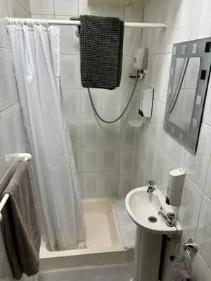 a white bathroom with a shower and a sink at Lee & Chris's Belvedere - Adults Only in Blackpool