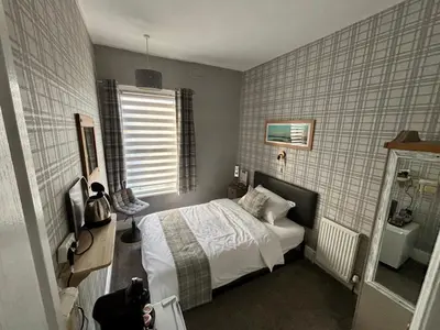 a small bedroom with a bed and a television at Lee & Chris's Belvedere - Adults Only in Blackpool