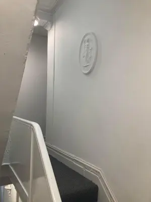 a stairway with a clock on a white wall at The New Astoria Hotel in Blackpool