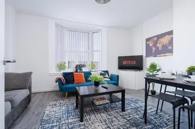 a living room with a blue couch and a table at Beautiful apartment dos - free public parking in Litherland