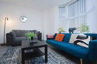 a living room with a blue couch and a table at Beautiful apartment dos - free public parking in Litherland