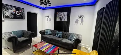 a living room with a couch and a chair at 4 bed 4 bath House with Free Parking, 5 Mins to LFC and 15 Mins to City Centre in Liverpool
