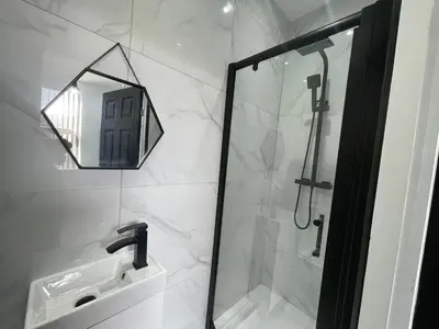 a bathroom with a shower and a sink and a mirror at 4 bed 4 bath House with Free Parking, 5 Mins to LFC and 15 Mins to City Centre in Liverpool