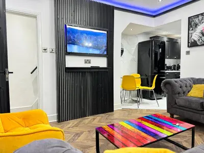 a living room with a tv and a colorful table at 4 bed 4 bath House with Free Parking, 5 Mins to LFC and 15 Mins to City Centre in Liverpool