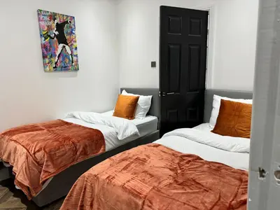 two beds sitting next to each other in a room at 4 bed 4 bath House with Free Parking, 5 Mins to LFC and 15 Mins to City Centre in Liverpool