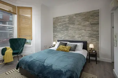 a bedroom with a bed and a brick wall at Seaside Suite 1 - Great Location Perfect For Long Stays in Blackpool