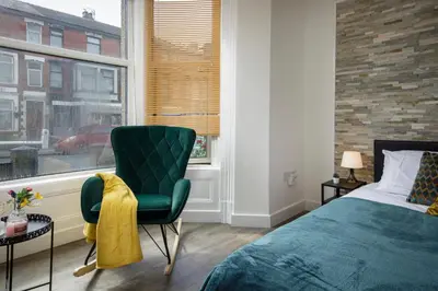 a bedroom with a bed and a chair and a window at Seaside Suite 1 - Great Location Perfect For Long Stays in Blackpool