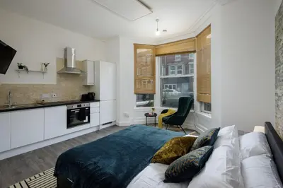 a bedroom with a bed and a kitchen at Seaside Suite 1 - Great Location Perfect For Long Stays in Blackpool