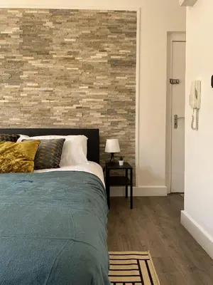 a bedroom with a bed and a brick wall at Seaside Suite 1 - Great Location Perfect For Long Stays in Blackpool