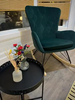 a green chair and a table with flowers on it at Seaside Suite 1 - Great Location Perfect For Long Stays in Blackpool