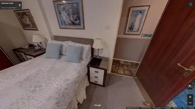 a bedroom with a bed with white sheets and blue pillows at Fairhaven Palentine Road in Blackpool
