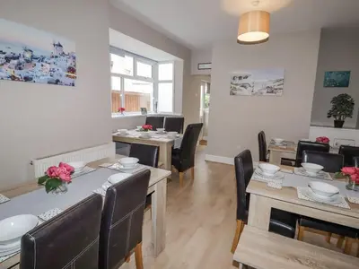 a living room with tables and chairs and a dining room at Marine House in Southport