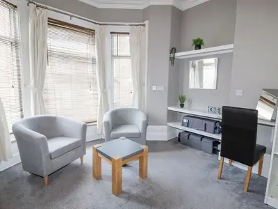 a living room with two chairs and a table at Marine House in Southport