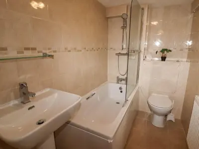 a white bathroom with a sink and a toilet at Marine House in Southport