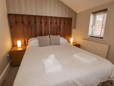 a bedroom with a large bed with two towels on it at Marine House in Southport