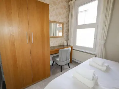a bedroom with a bed and a desk and a window at Marine House in Southport