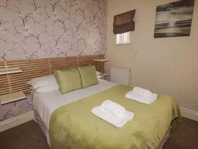 a bedroom with a bed with towels on it at Marine House in Southport