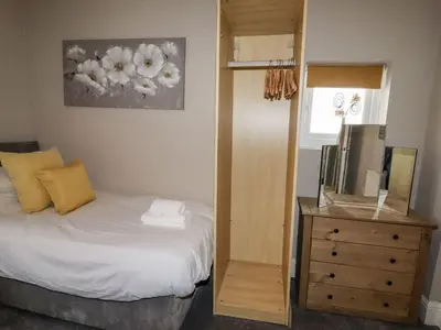 a bedroom with a bed and a dresser with a mirror at Marine House in Southport