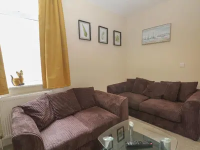 a living room with two brown couches and a window at Marine House in Southport