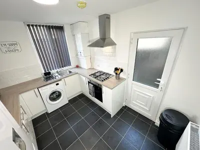a kitchen with a stove and a washer and dryer at Vicar Road in Liverpool
