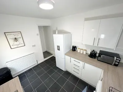 a kitchen with white cabinets and a white refrigerator at Vicar Road in Liverpool