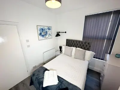 a small bedroom with a bed with white sheets and pillows at Vicar Road in Liverpool