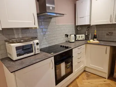 a kitchen with white cabinets and a microwave at 8 Coach House in Preston