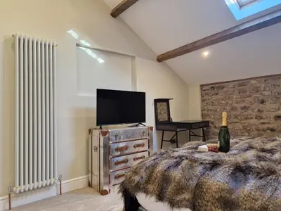 a bedroom with a bed and a tv on a dresser at 8 Coach House in Preston