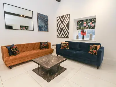 a living room with two couches and a table at 7 Holly Barn in Preston