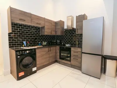 a kitchen with a refrigerator and a washer and dryer at 7 Holly Barn in Preston