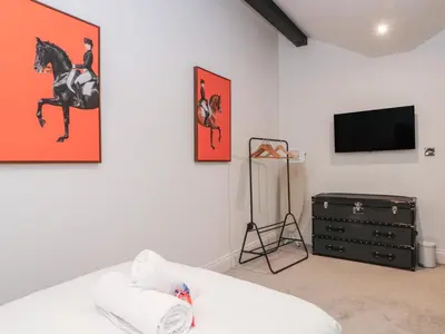 a living room with a tv and a horse painting on the wall at 7 Holly Barn in Preston