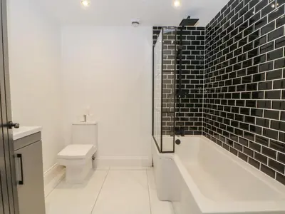 a bathroom with a tub and a toilet and a sink at 7 Holly Barn in Preston