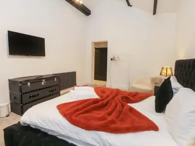 a bedroom with a bed with a red blanket on it at 7 Holly Barn in Preston