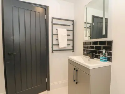 a bathroom with a black door and a sink at 7 Holly Barn in Preston
